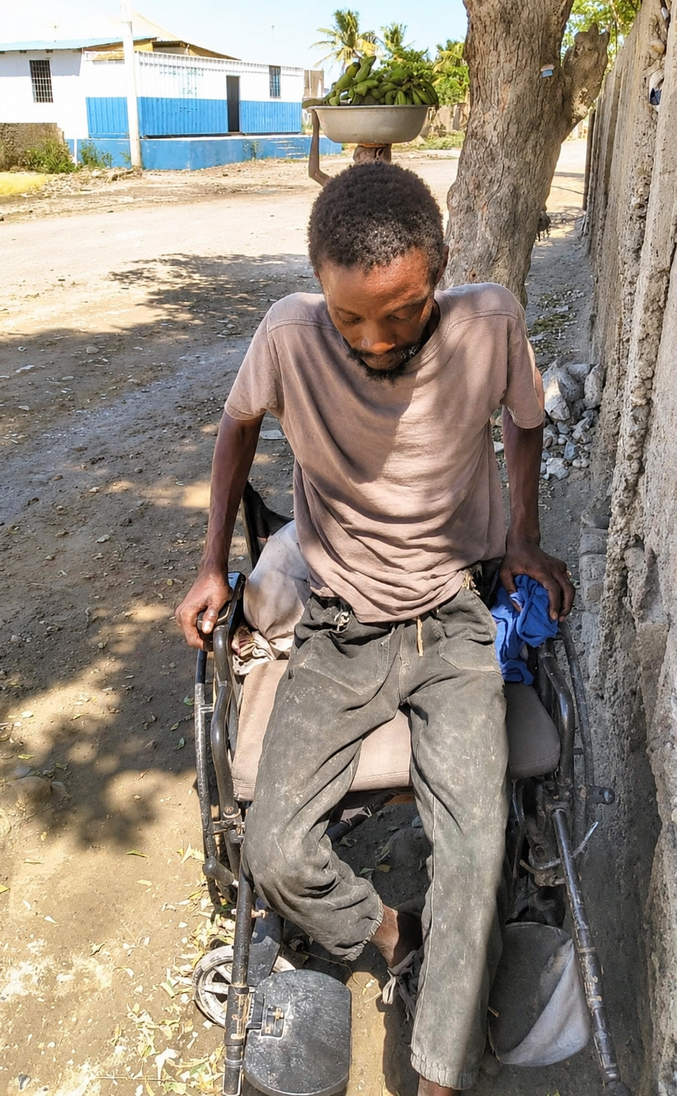Anthony, a blind man with physical disabilities, along a street in Haiti.